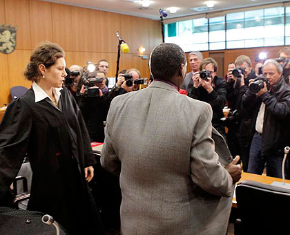Rwabukombe (in grey) is photographed by journalists as he awaits court ruling in Frankfurt yesterday.  Net photo.  