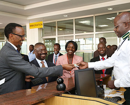 President Kagame presents his national ID to an immigration officer at Entebbe, Uganda marking the launch of national IDs as travel documents in East Africa. Village Urugwiro.