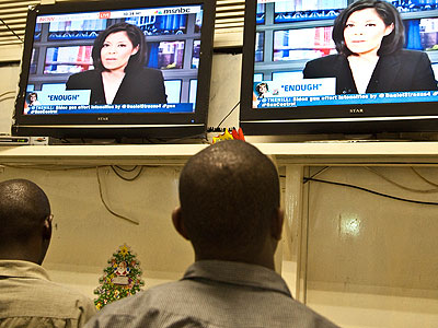 People watch news at one of the Pay TV firm outlets in town. File.