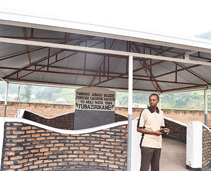 Innocent Kabanda stands next to the memorial site established in memory of thousands of Tutsis who were slain  and buried in the pit .  Jean du2019Amour Mbonyinshuti . 