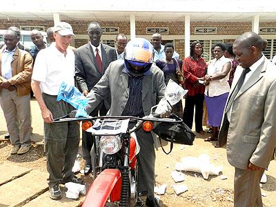 Heifer officials and Eastern Province Executive Secretary Jean Marie Vianney Makombe hand over a motorcycle to a farmer. Stephen Rwembeho