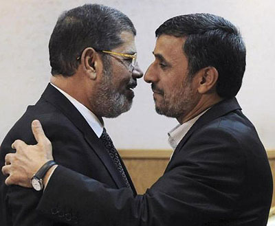 Morsi (L) stands accused of conspiring with foreign powers, Palestinian group Hamas and Iran. Here, he was with then Iran President Mahmoud Ahmadinejad. Net photo.