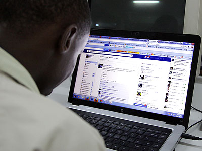 A young man looks at a Facebook page. John Mbanda
