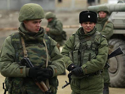 Military personnel stand next to an armoured personnel carrier (APC) in the Crimean port city of Feodosiya. Net photo.