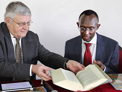 Chief Justice Sam Rugege (R), and former ICTR Judge Wolfgang Schomburg look through a book during the workshop yesterday. (John Mbanda)