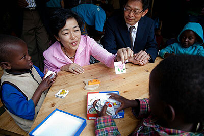 Japanese envoy Kazuga Ogawa and his wife play with children after the inauguration of the centre.  Collins Mwai.