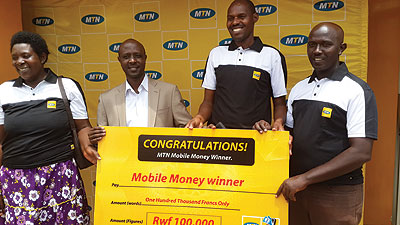 Some of the winners receive a dummy cheque from Munyampundu (second left) at the MTN Service Centre in Kimironko. The New Times/Ben Gasore.