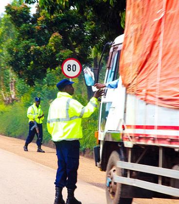  A traffic officer checks a driving permit of a truck driver along the Kigali-Huye highway. Timothy Kisambira. 