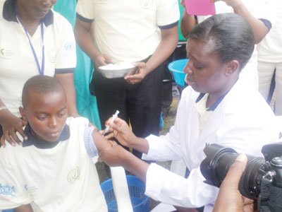 Minister Asiimwe administering a vaccine against cervical cancer during the launch. (Ivan Ngoboka)