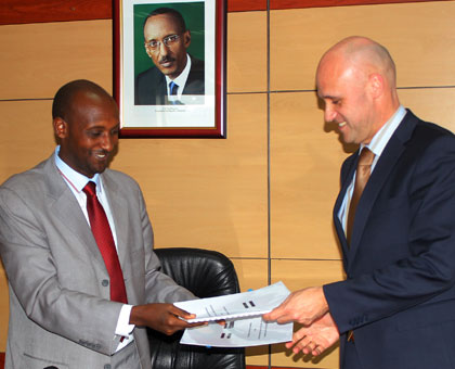  Richard Tushabe (L) and Peter P.E van Tienhoven exchange documents after signing the agreement on Thursday. Athan Tashobya. 