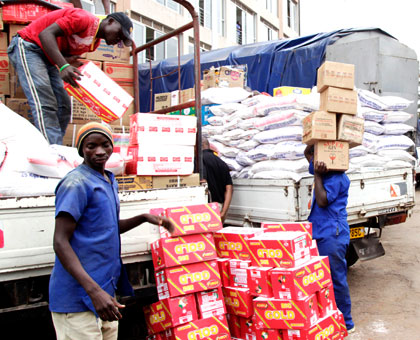 Workers offload goods at the outside retail shops in Kigali. John Mbanda. 