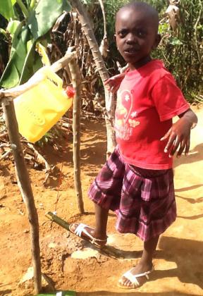 Umutesi uses Step-and-Wash apparatus at her family home compound. Seraphine Habimana.