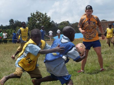 One of the visiting volunteer coaches (right) oversees a  training match for kids in Rulindo District last week. (Courtesy)