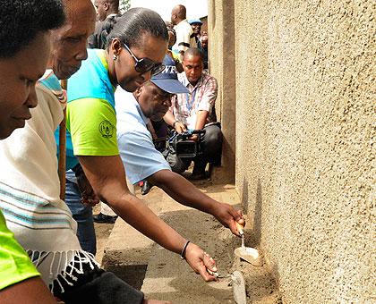 First Lady Jeannette Kagame helps to repair 83-year old widow Nyiramategeko Estheru2019s house. (Timothy Kisambira)