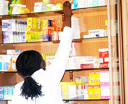 A pharmacist in Kigali picks drugs from the shelf to serve a client. UKu2019s GlaxoSmithKline pharmaceutical firm will enhance quality and access to drugs in the country once it sets....