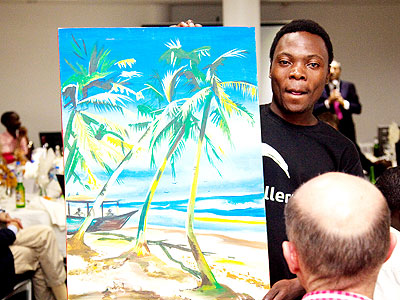 A 23-year-old Dominique Ndikumana, an orphan, displaying a painted piece of a Caribbean Imagination, during a fundraising ceremony for construction of a pre-school in Mudende Secto....