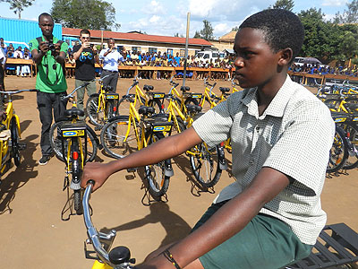 One of the beneficiaries from Nsinda Secondary School takes a ride on her bicycle. (Stephen Rwembeho)