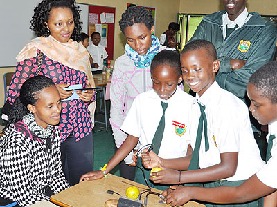 Students carry out an experiment as their parents look on in admiration. (Courtesy)