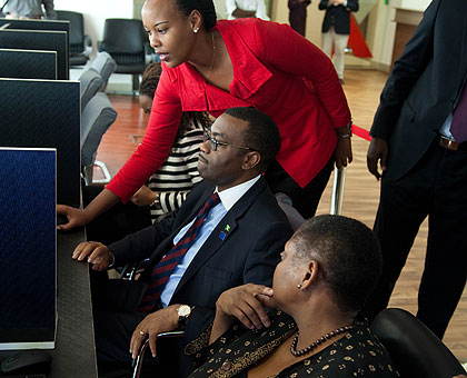 Aurore Mimosa Munyangaju, the trading manager of East African Exchange, shows the visiting Nigerian minister of agriculture and rural development Akinwumi Adesina (C) and Jenday....