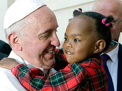 Pope Francis hugs a child. The pontiff preaches against religious intolerance. (Internet photo)