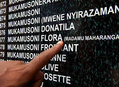 A survivor points at a name on the memoriam wall at Rebero Genocide memorial site yesterday.