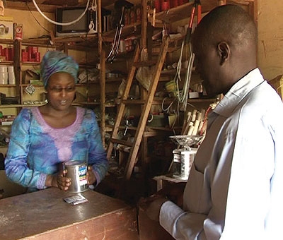 Umurerwa serves a client at her store. The New Times / Seraphine Habimana.