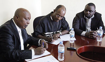 Nzeyimana (left) and Ciano sign the tenancy deal documents as another official looks on. The New Times/John Mbanda.