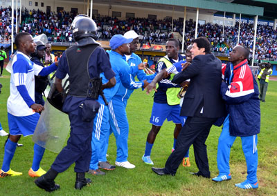 Rayon Sports head coach Luc Eymael and Cedric Amissi seen being restrained from attacking match officials yesterday at Amahoro stadium. S. Ngendahimana.