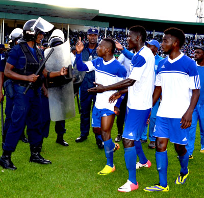 Rayon Sports skipper Fuadi Ndayisaba, center, leads his teammates into a faceoff with riot police at the Amahoro stadium on Sunday. S. Ngendahimana.