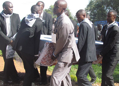Mourners carry a coffin containing remains of a Genocide victim at Kinazi memorial site on Monday. JP Bucyensenge.