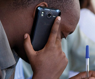 A man speaks on a mobile phone. Timothy Kisambira.