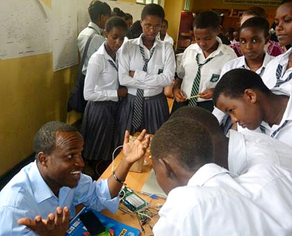 Eng. Gaspard Twagirayezu shows some of the students computer programming. Courtesy.
