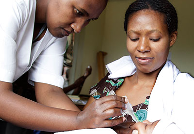 A nurse at the Kacyiru Police Hospital immunises a baby. Timothy Kisambira. 