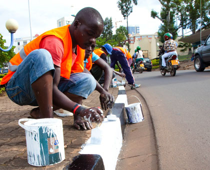 Workers give street pavement borders a fresh coat of paint yesterday. The City of Kigali is preparing to receive and host delegates coming in for the week-long 49th African Development Bank Annual Meetings slated for May 19-23.  Timothy Kisambira.