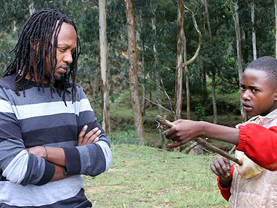 Mighty Popo watches a boy play a local musical instrument u2018Iningiriu2019. (Courtesy)