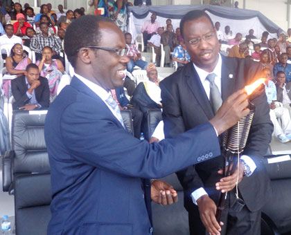 City of Kigali mayor Fidele Ndayisaba (L) and Culture and Sports minister Protais Mitali  light the Flame of Hope in honour of City employees killed during Genocide. Jean Tabaro.