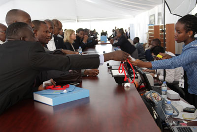 Delegates collect their accreditation cards before a series of AfDB meetings yesterday. John Mbanda. 