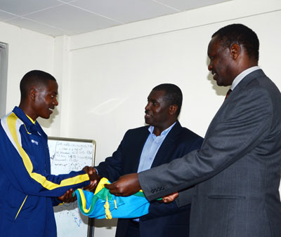 Team Rwanda captain James Sugira (L) receives the national flag from the director of sports in the ministry of Sports and Culture, Emmanuel Bugingo (C) and the National Olympic Committee president, Robert Bayigamba (R). S. Ngendahimana.
