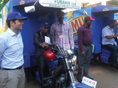 Tilburg (left) and other Bralirwa officials look on as the distributors try out the bikes. (Solomon Asaba)