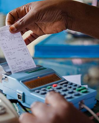 A trader in Quartier Matheus pulling a receipt out of the e-billing machine. File.