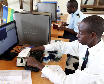 An immigration official at Nemba border post scans a travelleru2019s passport to access information through a computer recently. John Mbanda.