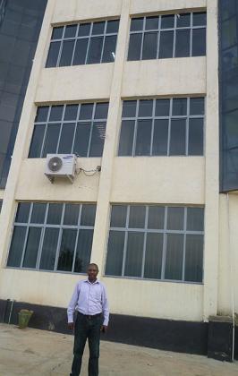 Ndagijimana in front of one of his commercial buildings, which houses banks like KCB among other businesses. The New Times / Seraphine Habimana.