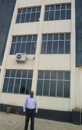 Ndagijimana in front of one of his commercial buildings, which houses banks like KCB among other businesses. The New Times / Seraphine Habimana.