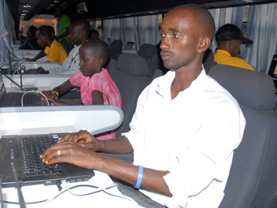 Locals using computers in an ICT bus. ICT has enhanced transfer of money across the region. (Timothy Kisambira)