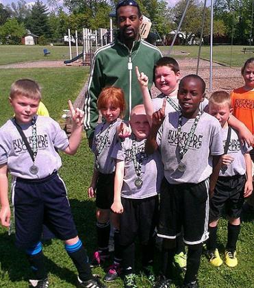 Moses Kamanzi poses with a group of youngsters at his Ohio-based Riverside Youth Soccer Club. Courtesy.