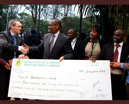 Staff of Bank Populaire give a dummy cheque worth over Rwf140m to former finance minister John Rwangombwa in 2012. John Mbanda.