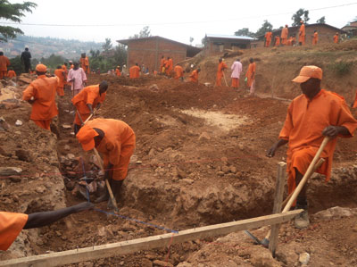 Inmates build a foundation for the new classroom block at Nyagatovu Primary School. In the background are the already finished blocks. Athan Tashobya.