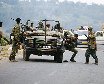 French soldiers hand over an unwilling Genocide victim to militiamen at a road block during the Genocide. (File)