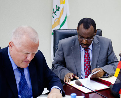 German Ambassador to Rwanda Peter Fahrenholtz( L), and Finance minister Claver Gatete ink a Rwf12.5 billion deal in Kigali yesterday. Timothy Kisambira.