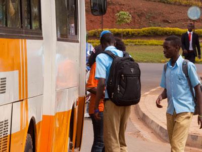 Students wait for their tickets before boarding  a bus to school. (Timothy Kisambira)
